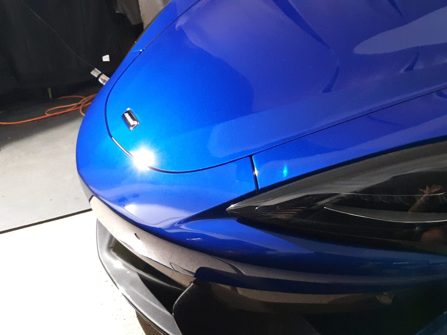 A blue car with some black trim on the hood