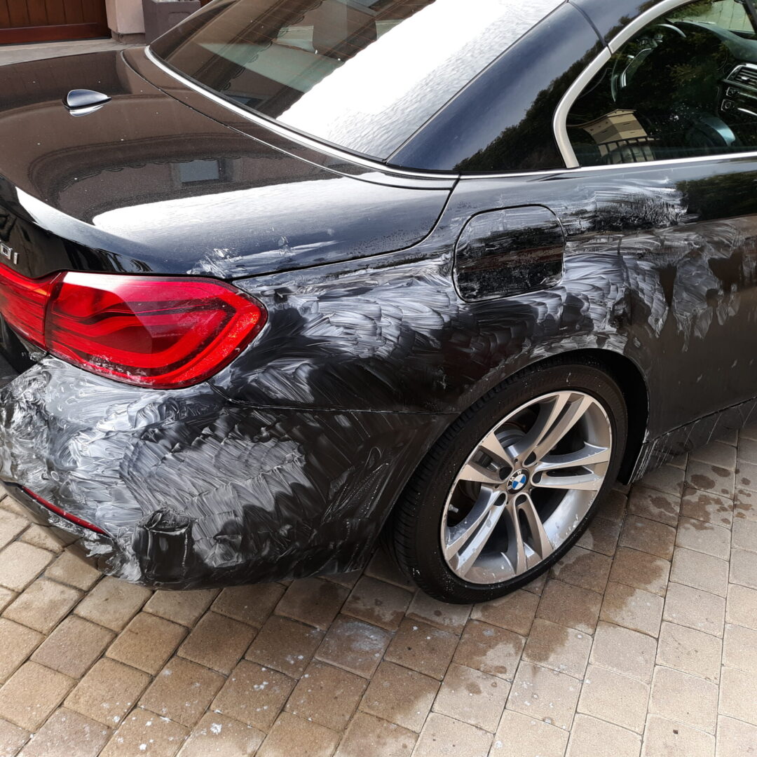 A black car with some white paint on it