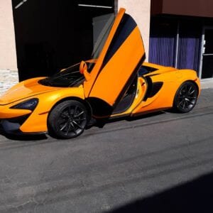 A yellow sports car with its doors open.