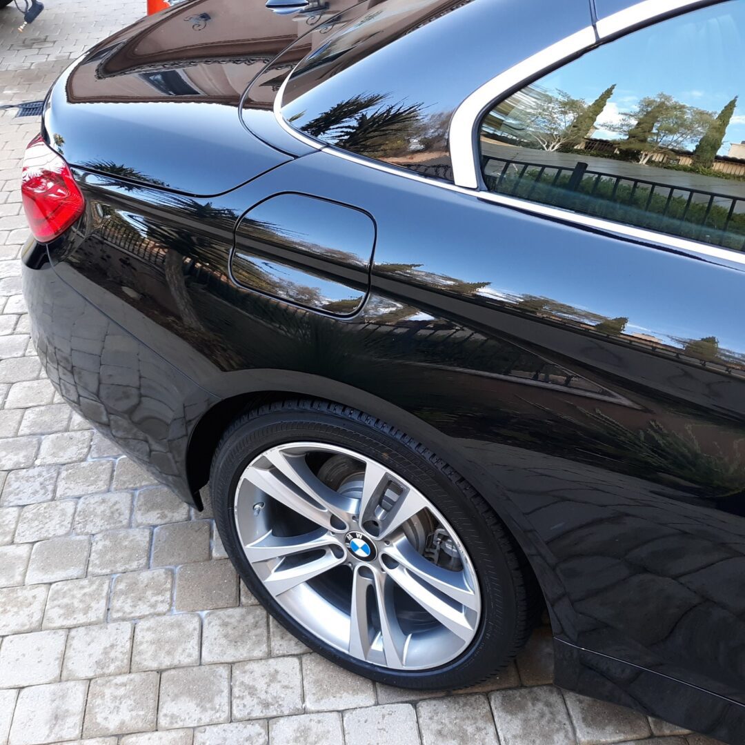 A black car parked on the side of a road.